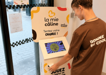 Client participant à un jeu Jackpot sur une borne interactive La Mie Câline.